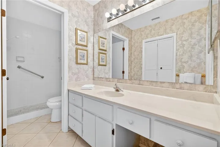 Bathroom with light tile patterned floors and vanity