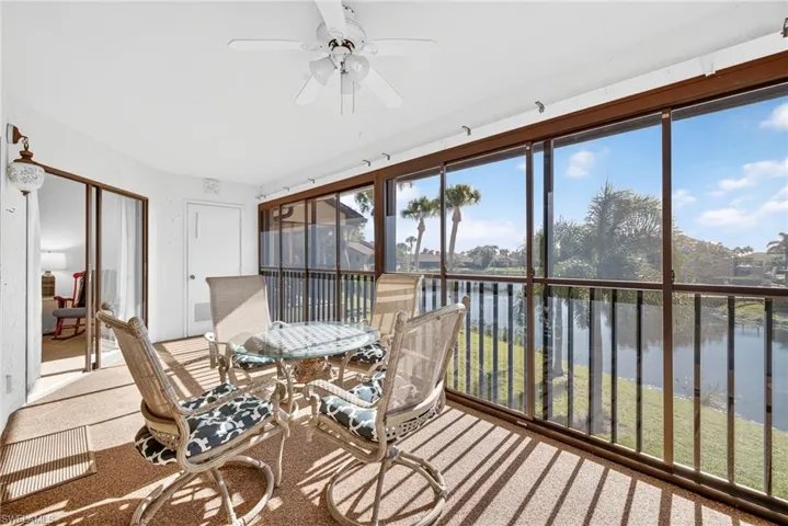 Sunroom / solarium featuring a water view and carpet floors