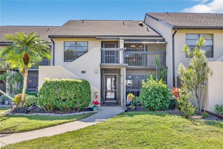 View of front of property with stucco siding and a front yard