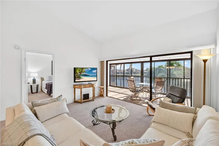 Carpeted living area with high vaulted ceiling