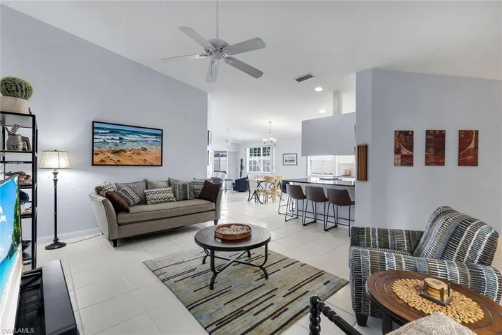 Spacious living area featuring vaulted ceilings, tile flooring, and an open concept layout