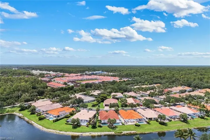 Aerial perspective showcasing a residential community with water frontage and extensive green space