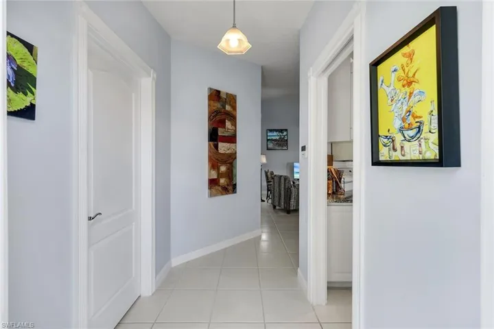 Hallway featuring light tile flooring and light blue wall paint