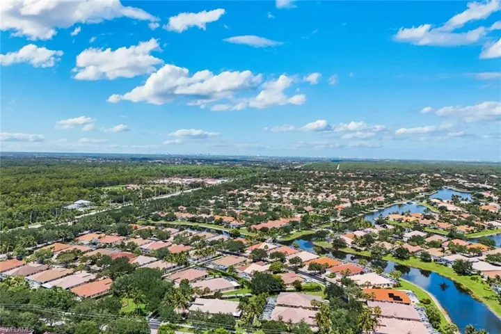 Extensive residential area featuring numerous homes with terracotta-style roofing, surrounded by lush green landscaping and mature trees