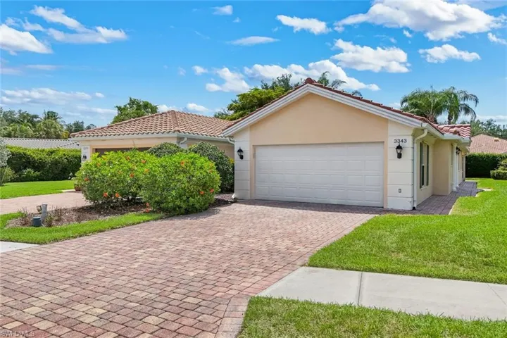 Stucco exterior with a tile roof and an attached garage