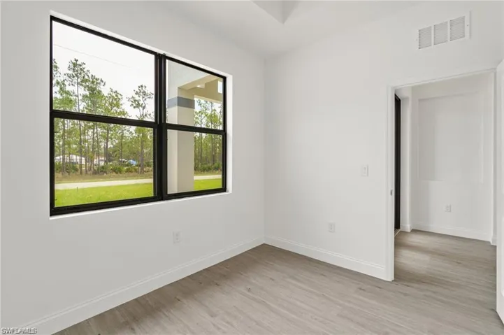 Spare room featuring light hardwood / wood-style flooring and plenty of natural light