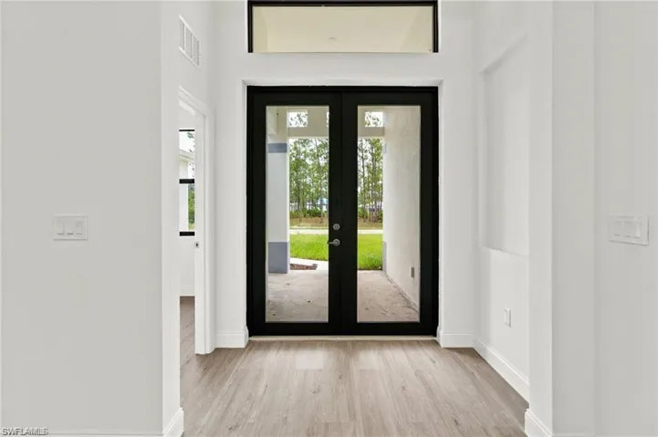 Entrance foyer featuring french doors and light hardwood / wood-style floors