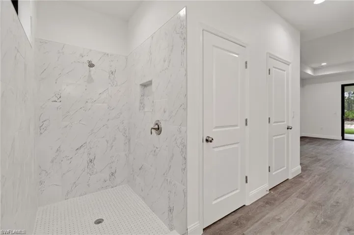 Bathroom featuring tiled shower and hardwood / wood-style floors