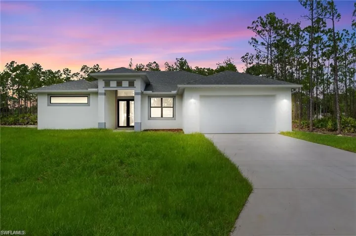 Prairie-style house with a garage and a lawn