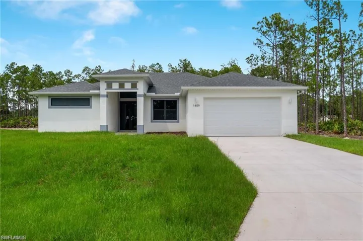 Prairie-style house featuring a garage and a front lawn