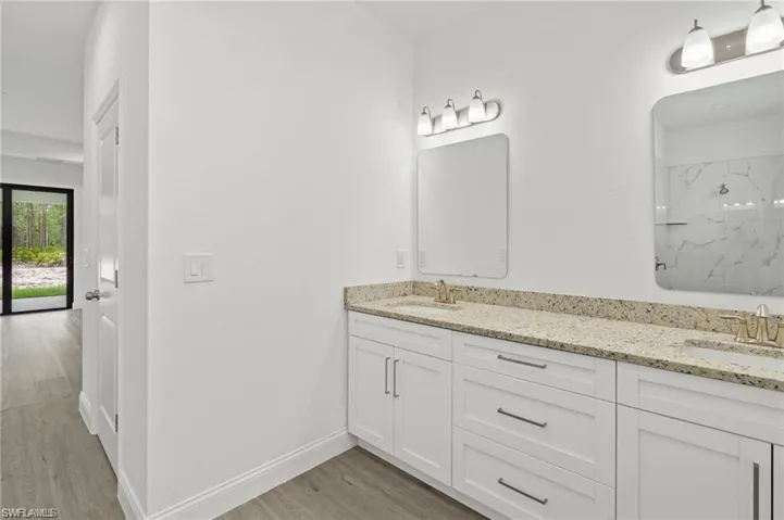 Bathroom with dual vanity and hardwood / wood-style floors