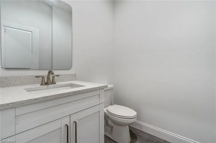 Bathroom featuring vanity, toilet, and wood-type flooring
