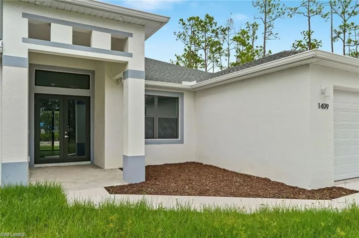 Entrance to property with a garage and french doors