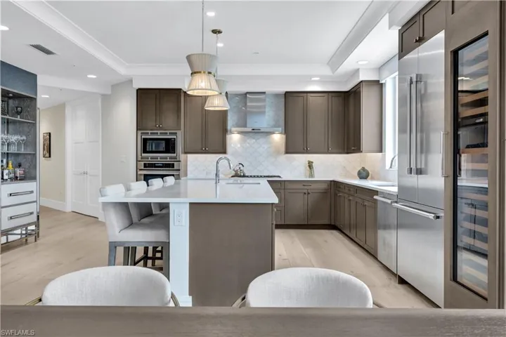 The kitchen boasts plenty of granite counterspace, stainless Thermador appliances, a built in sub-zero wine cooler, custom backsplash, liquor cabinet and custom lighting.