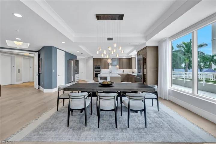 The private elevator lobby is to the left, dining and kitchen all with custom light fixtures.