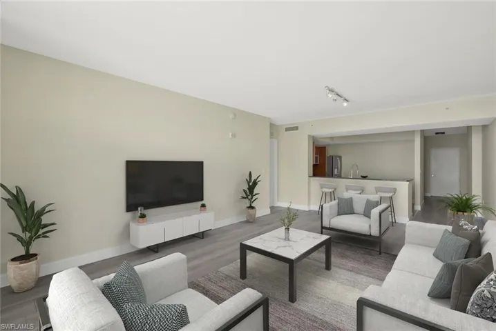 Open plan Living room with a wall of windows, large balcony with river and pool deck views, luxury vinyl flooring wood-type flooring - virtual staged