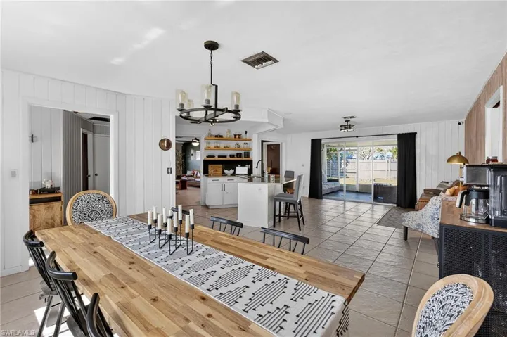 Dining area featuring wooden walls and a chandelier