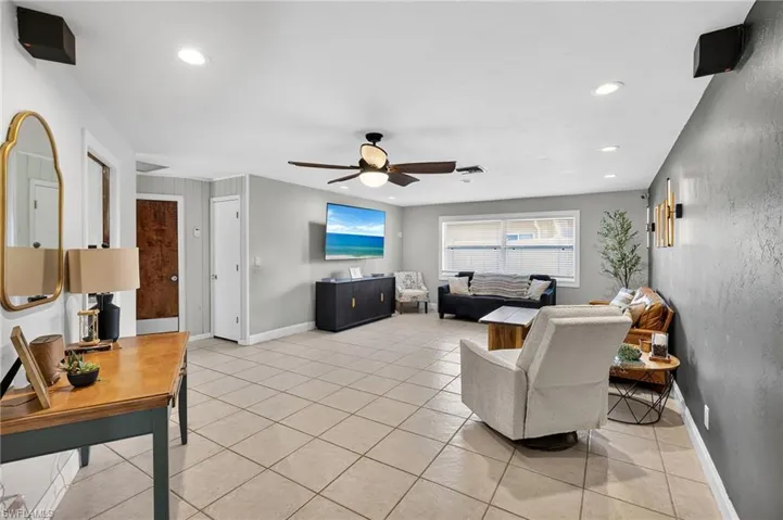 Living area featuring recessed lighting, light tile patterned flooring, and ceiling fan