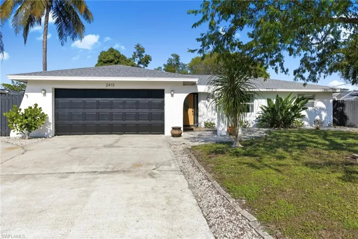 Ranch-style house with concrete driveway, stucco siding, and a garage