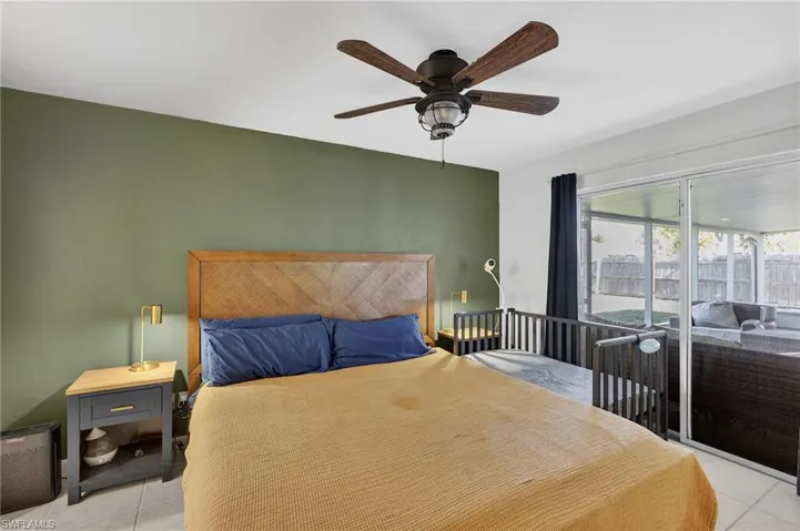 Bedroom featuring light tile patterned flooring, access to exterior, and ceiling fan