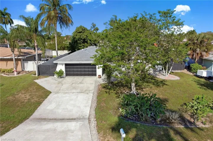 View of front facade with concrete driveway, an attached garage, stucco siding, and a shingled roof