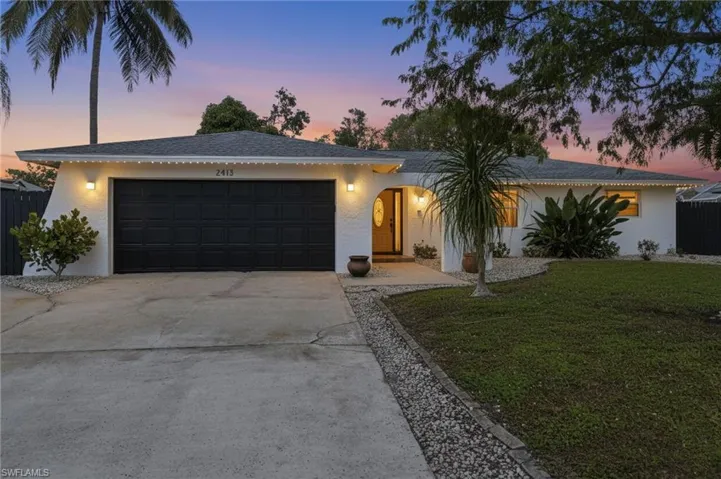 Single story home featuring driveway, a front yard, stucco siding, an attached garage, and a shingled roof