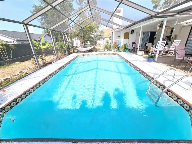 View of pool featuring a patio, a fenced backyard, a lanai, and a ceiling fan