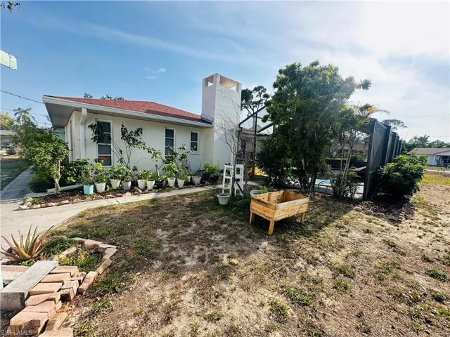 Rear view of house with a lanai, stucco siding, and a chimney