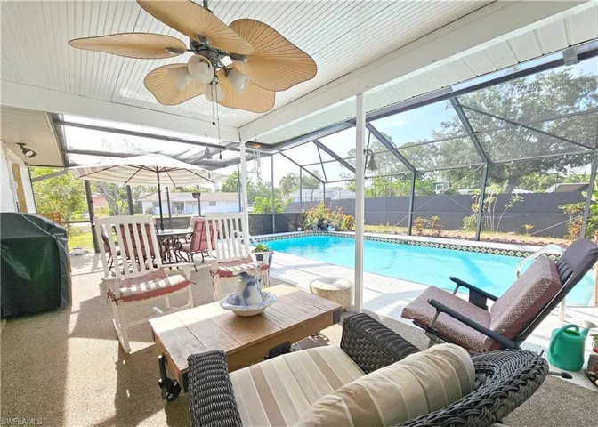View of swimming pool with a patio, a fenced backyard, glass enclosure, and outdoor dining space