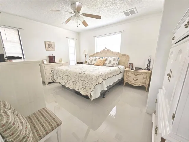 Bedroom with a textured ceiling and ceiling fan