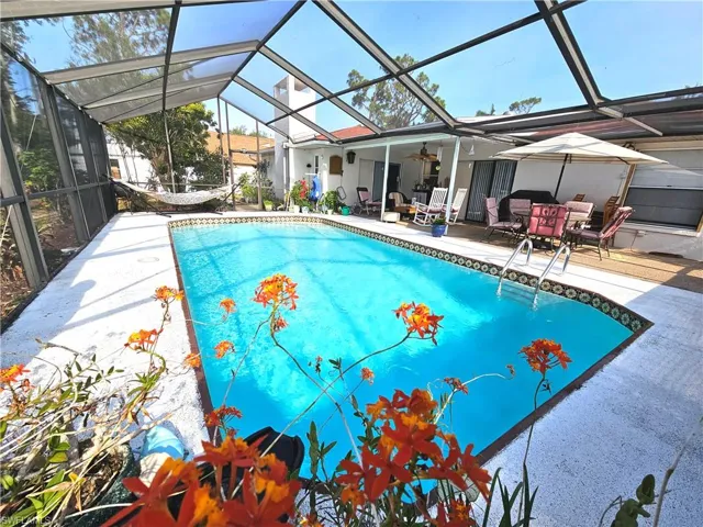 Swimming pool with a patio area, a ceiling fan, and a lanai