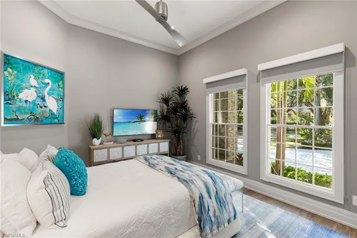 Bedroom with ornamental molding and wood finished floors