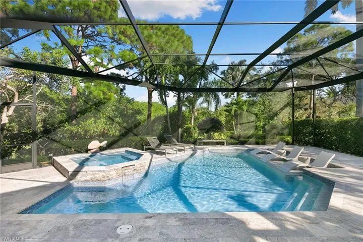 Integrated pool / spa with a sunroom, glass enclosure, and a patio