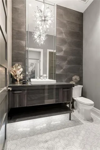 Half bathroom featuring vanity and an accent wall