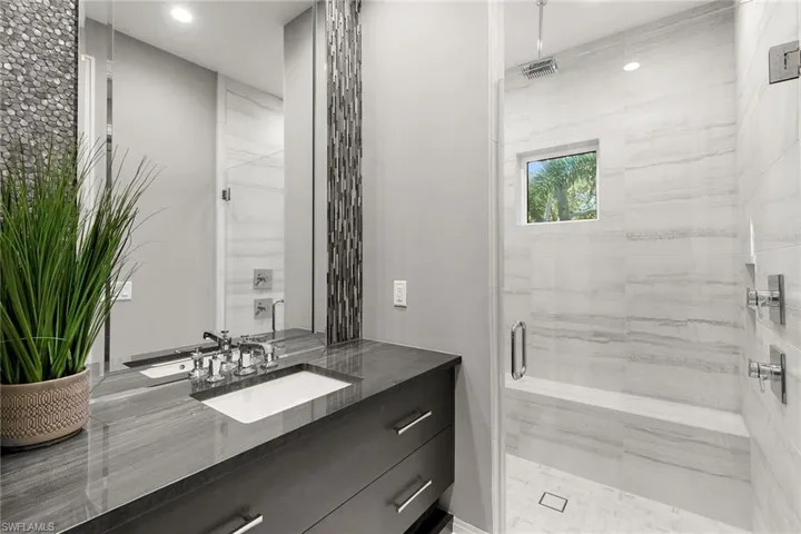 Bathroom with a marble finish shower and vanity