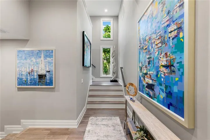 Stairway featuring wood finished floors and a high ceiling