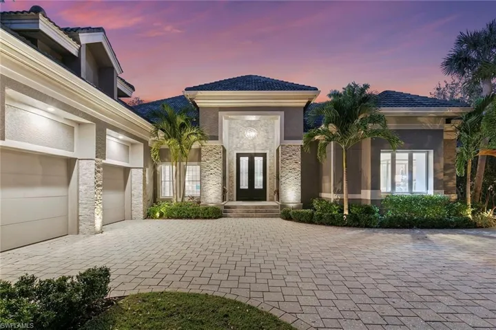 Exterior entry at dusk featuring french doors, decorative driveway, and stucco siding