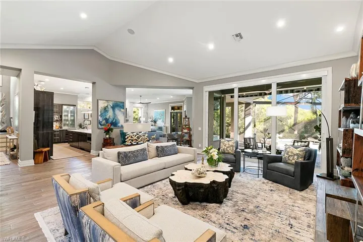 Living room featuring light wood-style flooring, ornamental molding, and recessed lighting