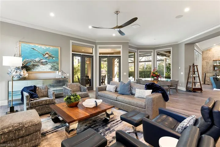Living room with ceiling fan, ornamental molding, plenty of natural light, wood finished floors, and recessed lighting