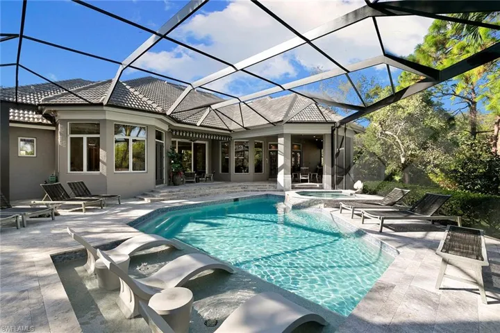 Combined pool / hot tub featuring a sunroom, a lanai, and a patio area