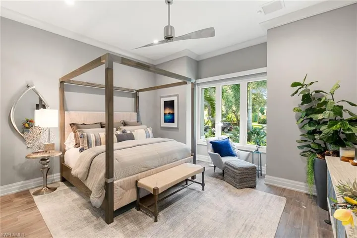 Bedroom featuring ornamental molding, light wood-style floors, and ceiling fan