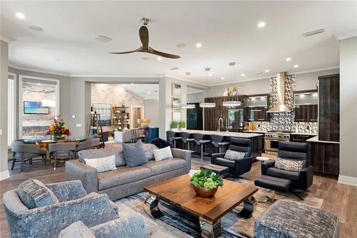 Living area featuring light wood-style floors, crown molding, ceiling fan, and recessed lighting