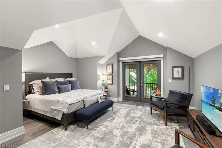 Bedroom featuring french doors, access to outside, and wood finished floors