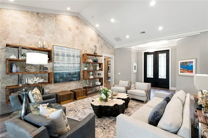 Living area featuring french doors, lofted ceiling, wood finished floors, recessed lighting, and ornamental molding