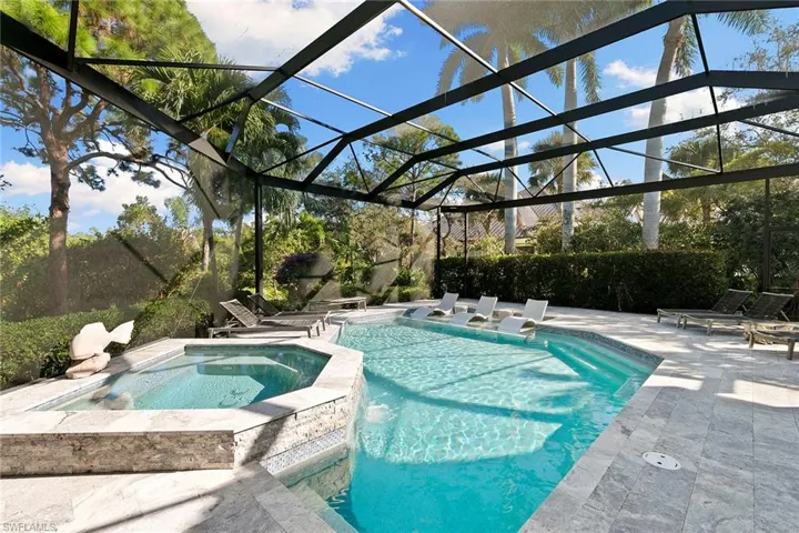 Integrated pool / spa featuring glass enclosure, a patio area, and a sunroom
