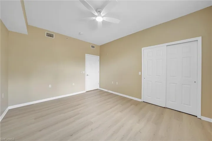 Unfurnished bedroom featuring light wood-style flooring, ceiling fan, and a closet