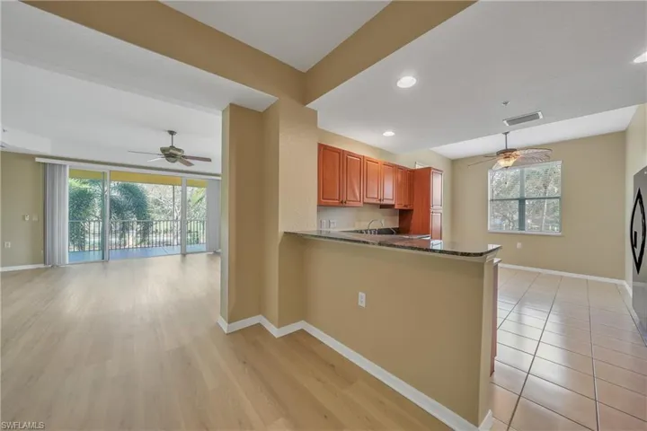 Kitchen with a ceiling fan, open floor plan, a peninsula, light wood-style flooring, and recessed lighting