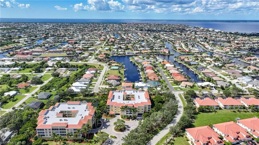 Aerial perspective of suburban area featuring a nearby body of water