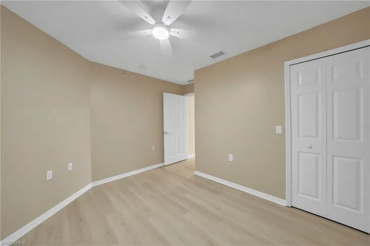 Unfurnished bedroom featuring light wood-type flooring, a closet, and a ceiling fan