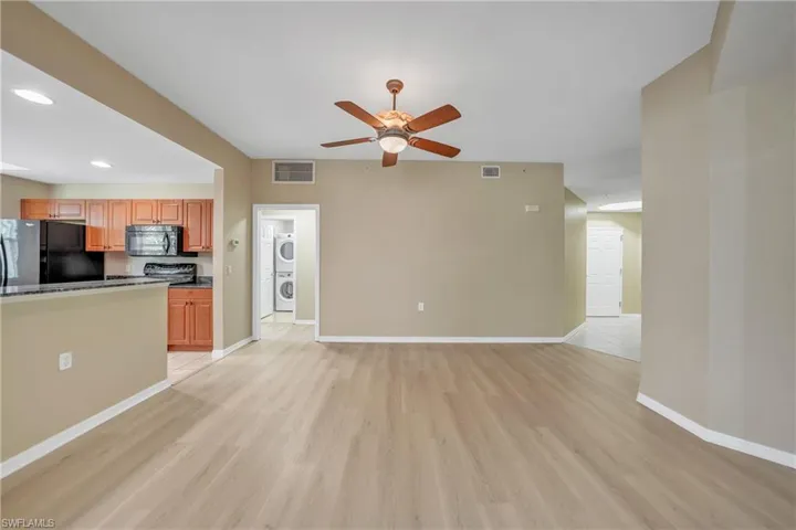 Unfurnished living room with light wood finished floors, recessed lighting, a ceiling fan, and stacked washing machine and dryer
